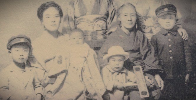 Setsuo Ishino as a toddler holding a model aircraft, with his family